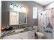 Gray bathroom featuring a granite countertop vanity and a shower-tub combination with Paris-themed curtain at 13634 7Th Avenue Ne Cir, Bradenton, FL 34212