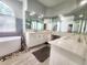 Bright bathroom features a soaking tub, dual vanities, quartz countertops and decorative tile at 13634 7Th Avenue Ne Cir, Bradenton, FL 34212