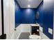 Charming powder room with navy blue walls, white wainscoting, black and white flooring, and a gold framed mirror at 13634 7Th Avenue Ne Cir, Bradenton, FL 34212