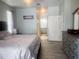 Bright main bedroom with wood-look floors, ensuite bathroom, dresser with mirror, and neutral decor at 13634 7Th Avenue Ne Cir, Bradenton, FL 34212