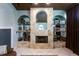 Elegant fireplace with detailed stone work, glass shelving, and decorative accents at 13634 7Th Avenue Ne Cir, Bradenton, FL 34212