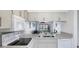 Bright kitchen with white countertops and appliances, view to living room at 2124 N Tamiami Trl # 103, Sarasota, FL 34234