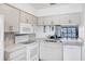Bright kitchen with white appliances and a view to the living room at 2124 N Tamiami Trl # 103, Sarasota, FL 34234