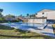 Community pool with clear blue water, lounge chairs, and building exterior against a clear sky at 2124 N Tamiami Trl # 103, Sarasota, FL 34234