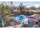 Aerial view of a community pool with lounge chairs, table, and nearby trees offering shade at 2124 N Tamiami Trl # 103, Sarasota, FL 34234