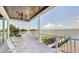 Peaceful balcony overlooking the water with white chairs and beautiful views at 2516 Avenue A, Bradenton Beach, FL 34217