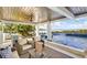 Relaxing pool area with covered patio, outdoor seating, and water views at 2516 Avenue A, Bradenton Beach, FL 34217