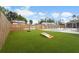 Spacious backyard featuring a pool, turf area, cornhole boards, and a wooden fence at 3507 68Th W St, Bradenton, FL 34209