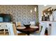 Bright dining area with a round table and four chairs, featuring decorative wallpaper at 4046 Overture Cir # 4046, Bradenton, FL 34209