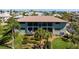 An exterior view of a multi-Gathering home shows a screened-in lanai and tropical landscaping at 4255 Gulf Dr # 116, Holmes Beach, FL 34217