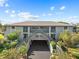 Front view of a two-story building with a parking area underneath and lush landscaping at 4255 Gulf Dr # 116, Holmes Beach, FL 34217