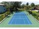 Aerial view of a well-maintained community tennis court with blue and green surface at 4255 Gulf Dr # 116, Holmes Beach, FL 34217