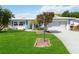 White single story home with teal accents, landscaped lawn, and attached garage at 4301 Teakwood Cir, Bradenton, FL 34208