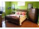 Green bedroom with wooden furniture and floral bedding at 5613 Key Largo Ct, Bradenton, FL 34203
