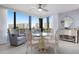 Elegant dining area with a glass-top table and white chairs, near a window with water views at 5780 Midnight Pass Rd # 205, Sarasota, FL 34242