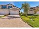 Brick paver driveway, lush landscaping, and two-car garage at 6035 Worsham Ln # 104, Lakewood Ranch, FL 34211