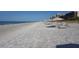 Sandy beach with lounge chairs and umbrellas facing the ocean at 1085 Gulf Of Mexico Dr # 301, Longboat Key, FL 34228