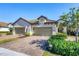 Charming home exterior with a two-car garage and brick paver driveway at 11265 Mc Dermott Ct, Englewood, FL 34223