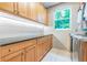 Bright laundry room with wood cabinets, granite countertops, and modern appliances at 1130 Anclote Rd, Tarpon Springs, FL 34689