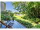 Backyard with a wooden deck, lush landscaping, and a serene pond with a fountain at 1720 Starling Dr # 103, Sarasota, FL 34231