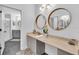Modern bathroom with dual vanity, circular mirrors, and updated fixtures at 1720 Starling Dr # 103, Sarasota, FL 34231
