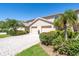 Townhome exterior with a paved driveway, lush landscaping, and attached garage at 1720 Starling Dr # 103, Sarasota, FL 34231