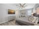 This bedroom features a tray ceiling, ceiling fan, wood-look floors, and stylish decor at 17744 Savory Mist Cir, Bradenton, FL 34211