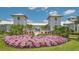 Beautiful clubhouse exterior with lush landscaping and a vibrant flowerbed in the foreground at 17744 Savory Mist Cir, Bradenton, FL 34211