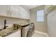 Functional laundry room with granite countertops and modern appliances at 17744 Savory Mist Cir, Bradenton, FL 34211