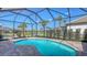 Inviting screened-in pool area with brick pavers and a beautiful view of the surrounding landscaping at 17744 Savory Mist Cir, Bradenton, FL 34211