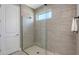 Modern shower with glass enclosure, neutral tile, and window at 17744 Savory Mist Cir, Bradenton, FL 34211