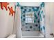 Modern bathroom with blue accent tile in shower, white fixtures, and bright natural light at 1775 Stapleton St, Sarasota, FL 34239