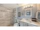 Bright bathroom featuring a tiled shower with decorative accents and a modern vanity with updated fixtures at 1775 Stapleton St, Sarasota, FL 34239