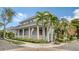 Inviting home featuring a spacious porch, columns, and lush landscaping at 1775 Stapleton St, Sarasota, FL 34239