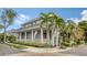 Gray two-story house with a red door, front porch, and palm trees at 1775 Stapleton St, Sarasota, FL 34239