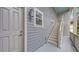 Exterior shot of a gray home showcasing the entrance door and stairway on the side of the home at 1775 Stapleton St, Sarasota, FL 34239