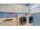 Well-appointed laundry room boasting new, front-loading washer and dryer, upper cabinets, and a utility sink at 1775 Stapleton St, Sarasota, FL 34239
