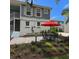 Charming outdoor patio space with a dining table, umbrella, and well-maintained landscaping at 1775 Stapleton St, Sarasota, FL 34239