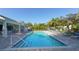 Community pool featuring inviting lounge chairs, mature landscaping, and a covered gazebo at 1775 Stapleton St, Sarasota, FL 34239