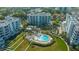 Aerial view of beachfront condominiums with a sparkling blue pool and lush landscaping at 2105 Gulf Of Mexico Dr # 3303, Longboat Key, FL 34228