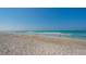 A person walks the shoreline along the white sand in this beach view at 2105 Gulf Of Mexico Dr # 3303, Longboat Key, FL 34228