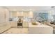 Modern kitchen features white cabinetry, stainless steel appliances, marble floors, and a center island at 2105 Gulf Of Mexico Dr # 3303, Longboat Key, FL 34228