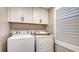 Bright laundry room features a modern washer and dryer, cabinetry, and natural light through plantation shutters at 2105 Gulf Of Mexico Dr # 3303, Longboat Key, FL 34228