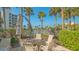 Inviting outdoor patio area with seating around a cozy fire pit, surrounded by tropical landscaping at 2105 Gulf Of Mexico Dr # 3303, Longboat Key, FL 34228