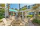 Inviting outdoor patio area with seating around a cozy fire pit, surrounded by tropical landscaping at 2105 Gulf Of Mexico Dr # 3303, Longboat Key, FL 34228