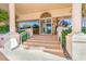 Inviting building entrance with stone steps, lush landscaping, and elegant columns at 3070 Grand Bay Blvd # 612, Longboat Key, FL 34228