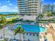 Stunning pool area with plenty of lounge chairs and umbrellas at 3070 Grand Bay Blvd # 612, Longboat Key, FL 34228