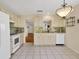 Kitchen boasts white cabinets, tile floors and view into adjoining room at 3541 Blechnum Fern Ln, Sarasota, FL 34235