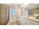Well-lit bathroom with a shower, neutral tile, and white vanity at 4409 Eleuthera Ct, Sarasota, FL 34233