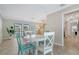 Bright dining area with white table, aqua and white chairs, and a view into the adjacent living room at 4409 Eleuthera Ct, Sarasota, FL 34233